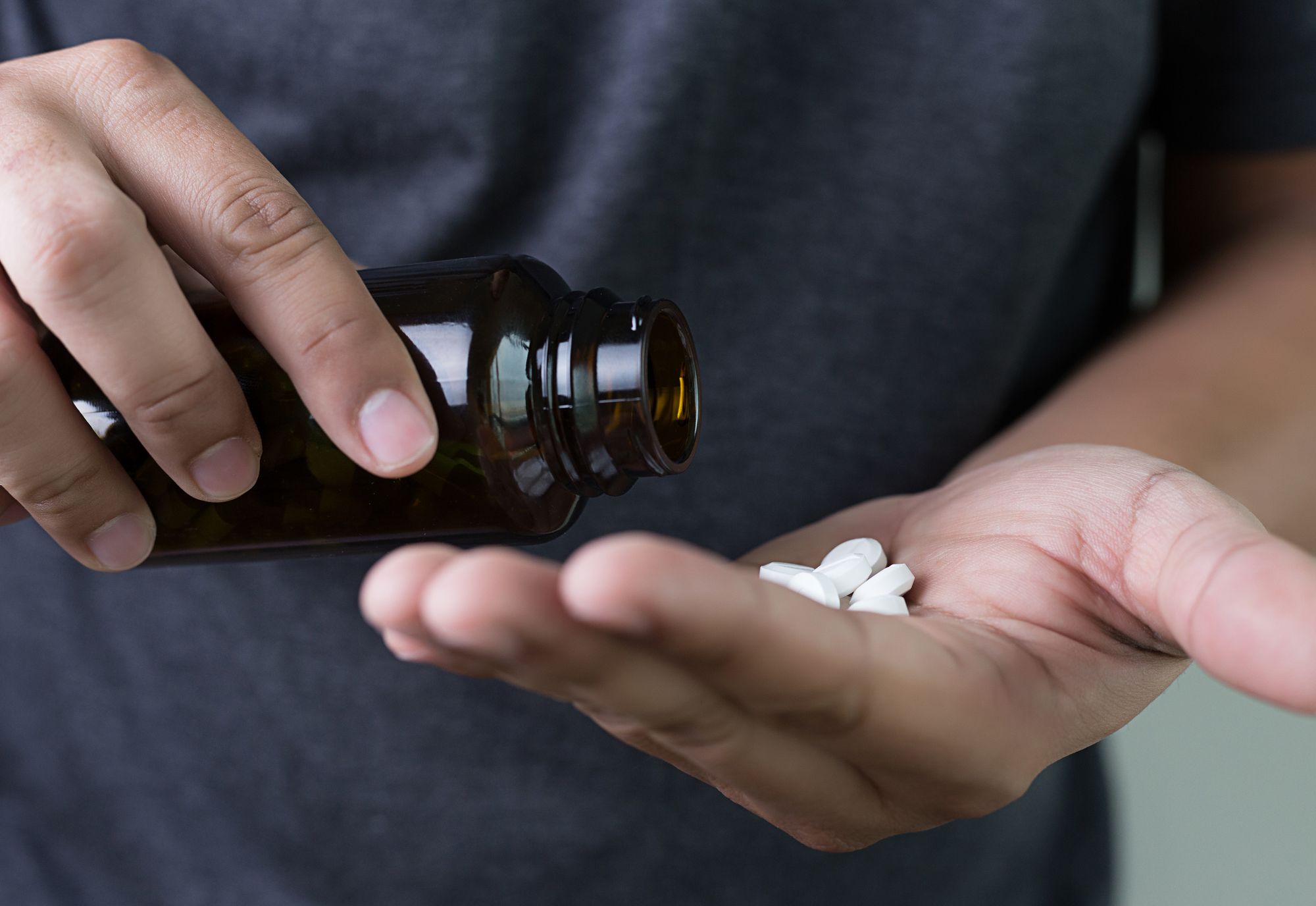 A man holding a bottle of DHEA supplement