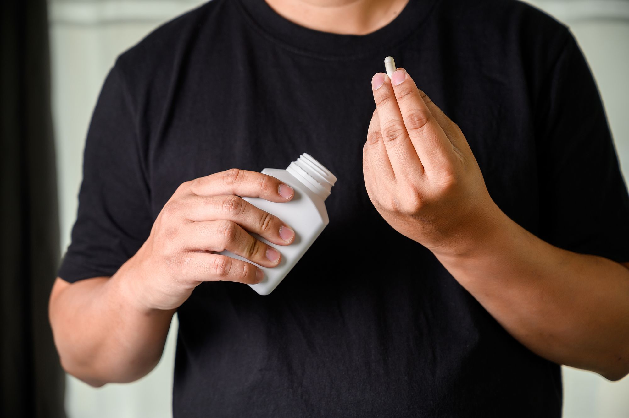 A man holding a bottle of Ginseng supplement