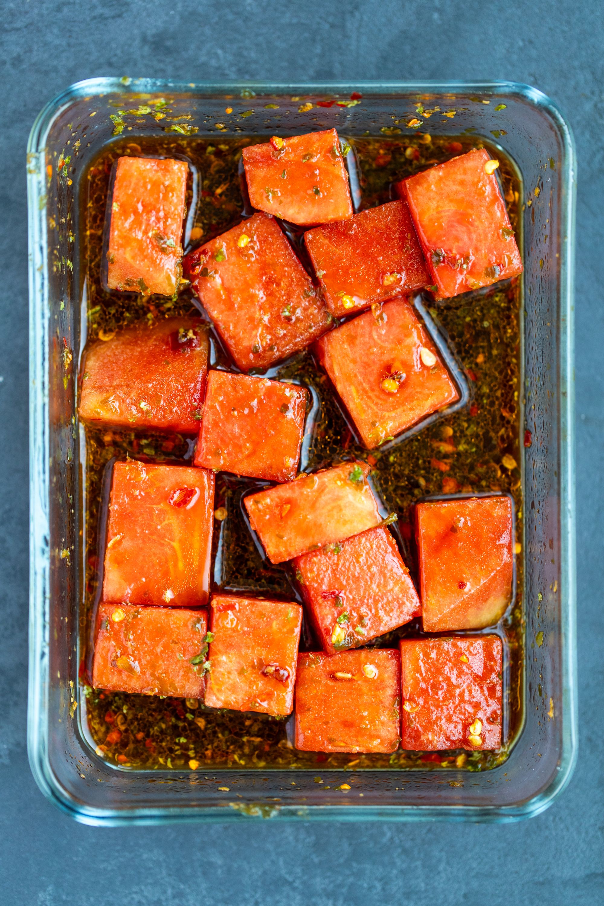 Watermelon marinating in a glass dish before being dehydrated into 'tuna'