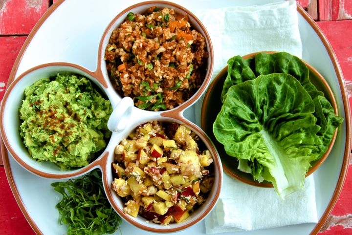 Mexican platter elements in a white dish with lettuce leaves on a white plate