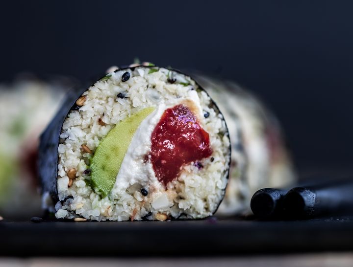 Watermelon sushi with chopsticks on a black plate