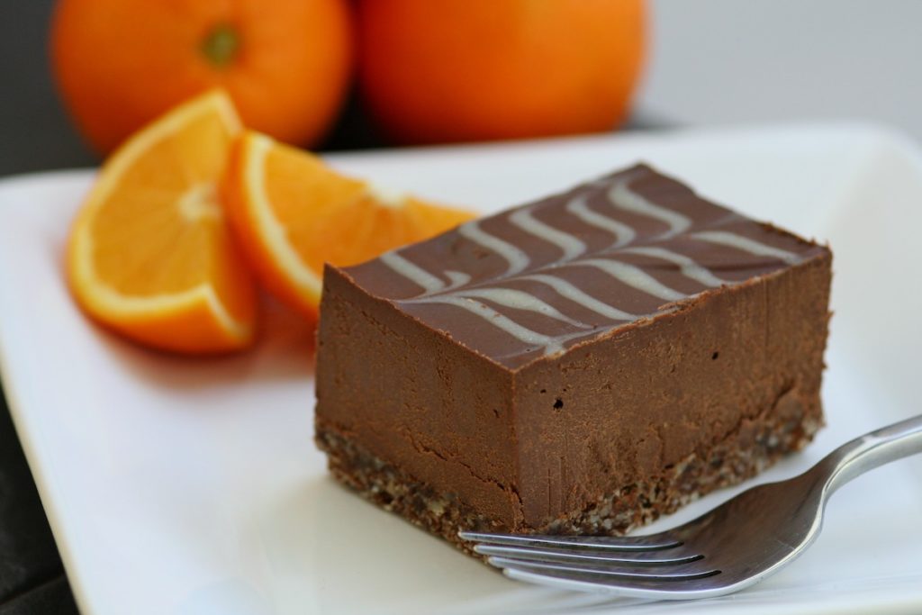 Marbled chocolate and orange tavoletta on a white plate with a fork 