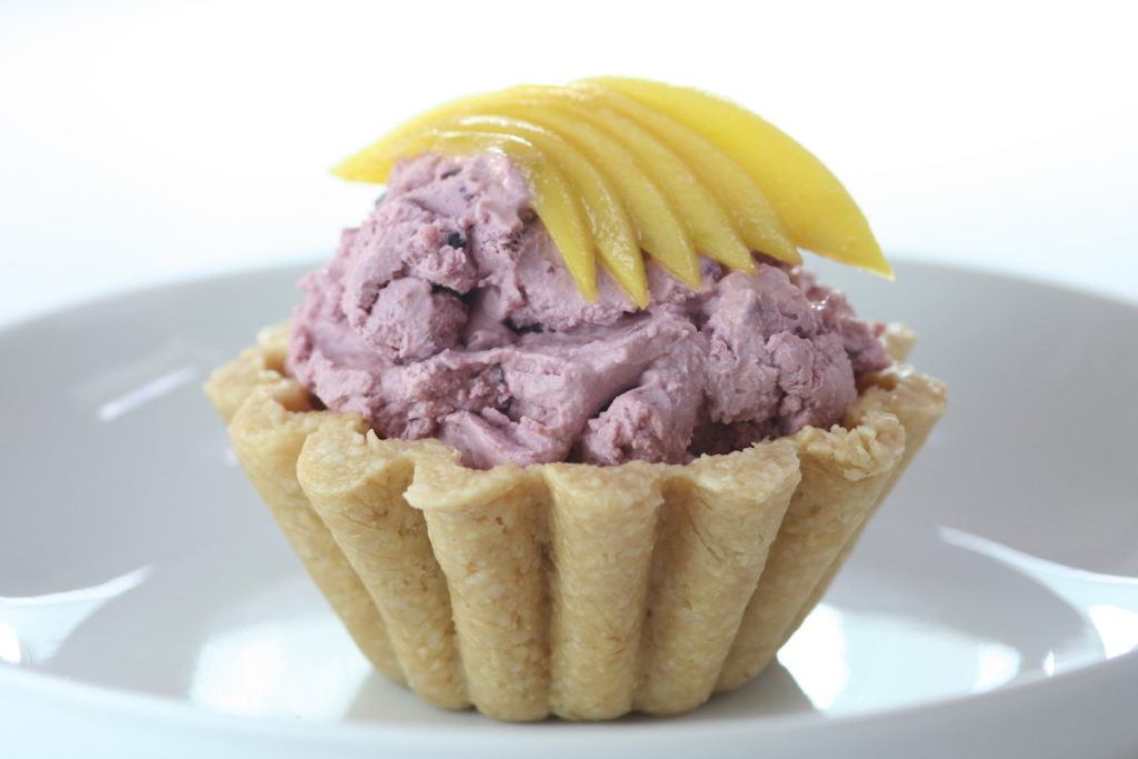 Cherry ice cream mango cup on a white plate