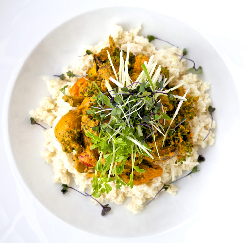 Raw curry overhead shot with microgreens on top, in a white bowl