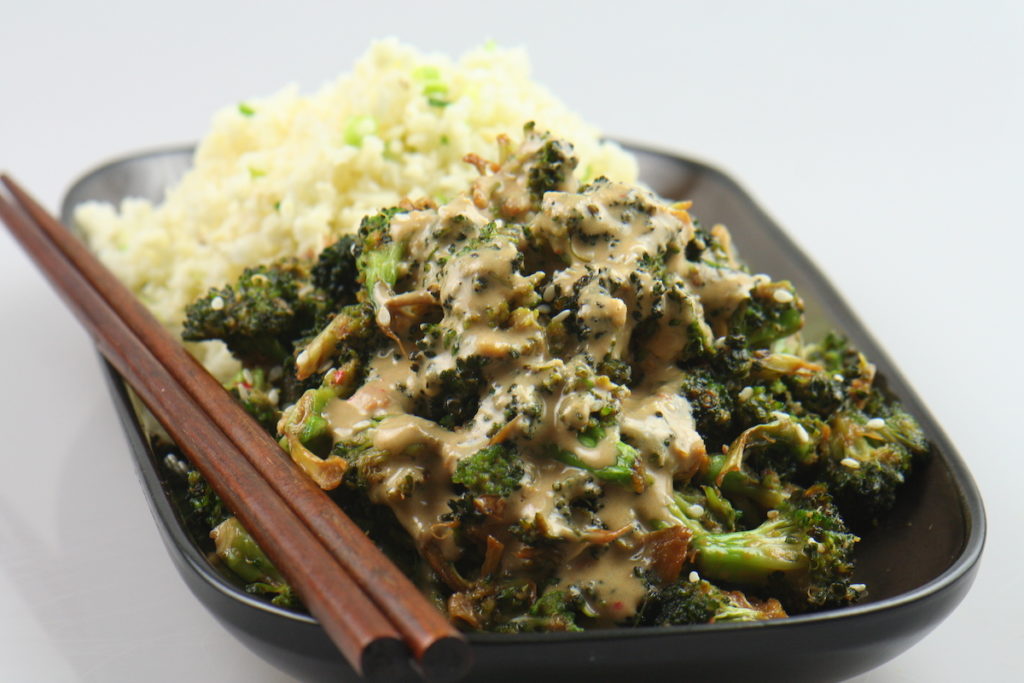 Broccoli Hoisini and parsnip rice in a black bowl on a white background