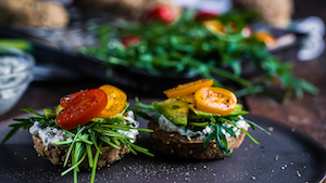 Raw vegan breakfast bagels with cashew sour cream on a black plate