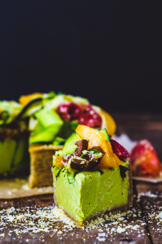 Slice of raw tomato basil tart on a wooden surface