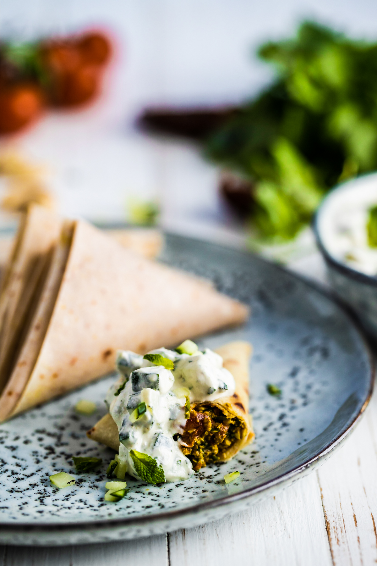 Coconut samosas on a blue plate and white wooden background