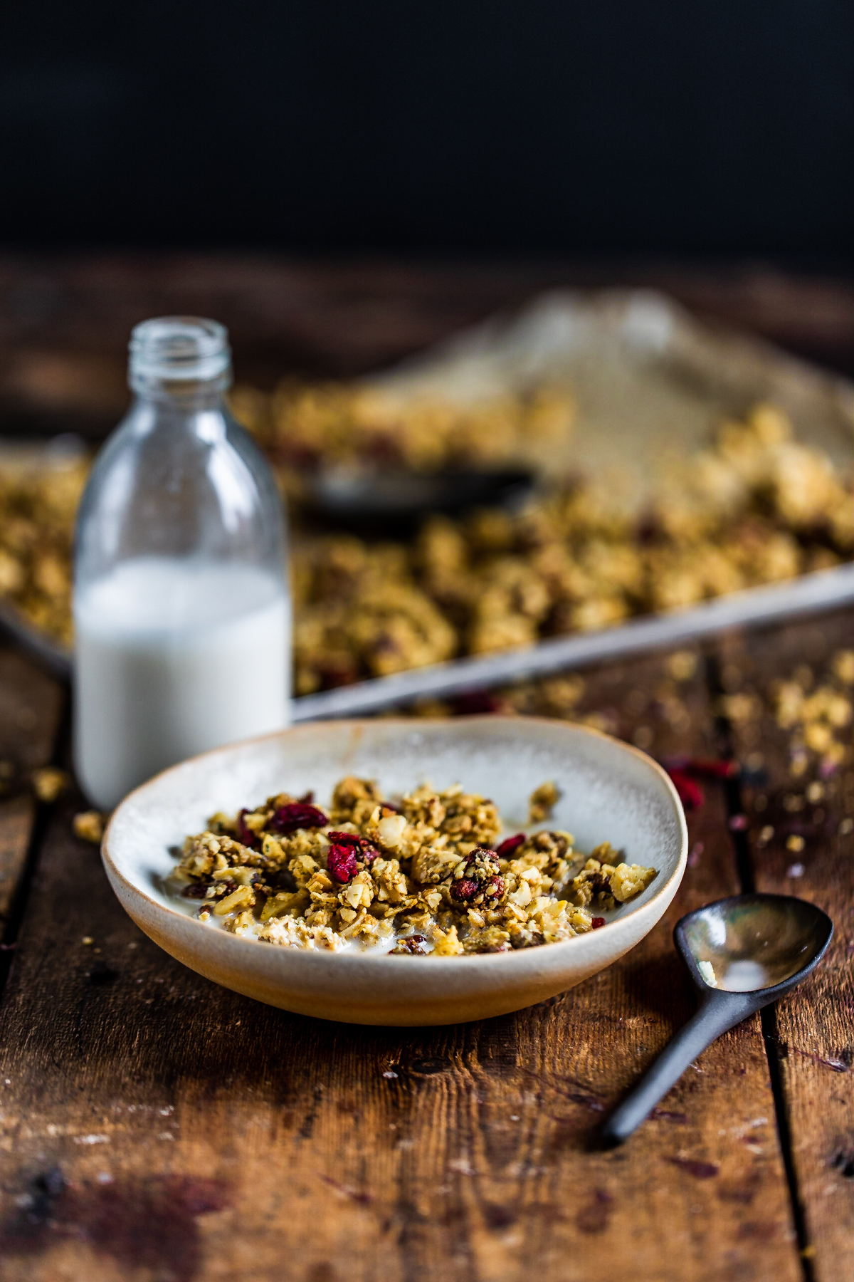 Hemp granola with almond milk in a white bowl on a wooden background