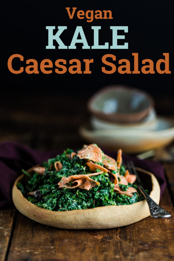 Vegan kale caesar salad in a brown bowl on a wooden background