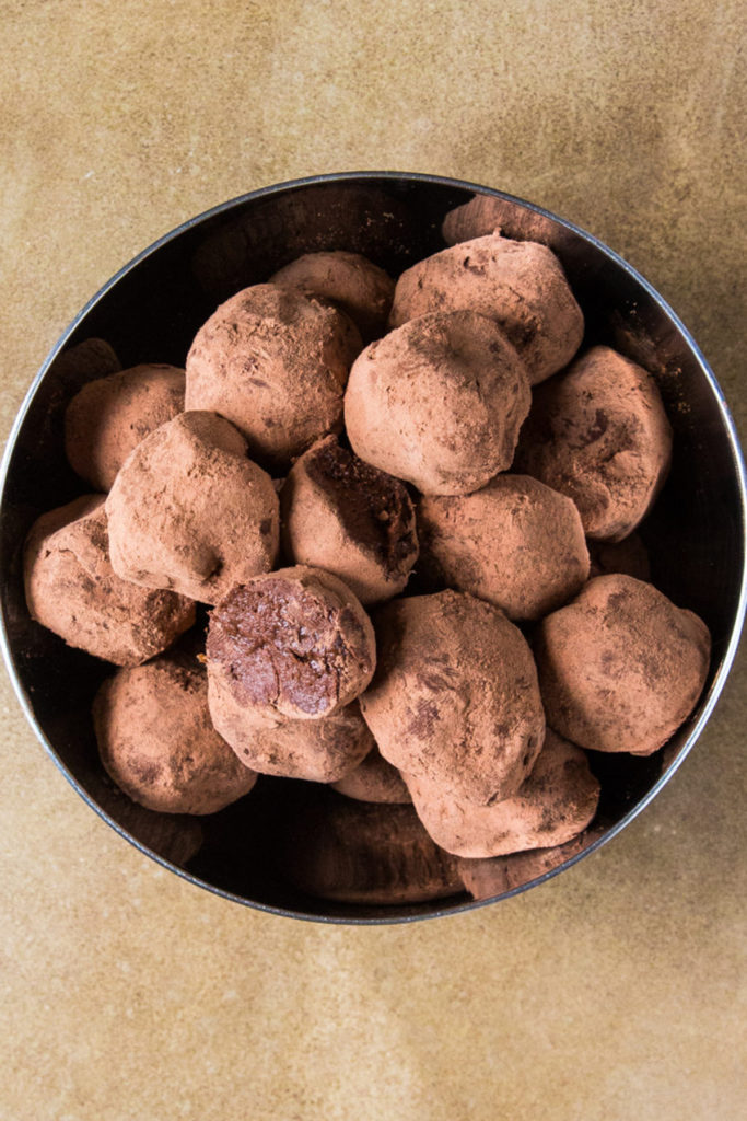 Raw Chocolate balls covered in cacao powder on a silver bowl.