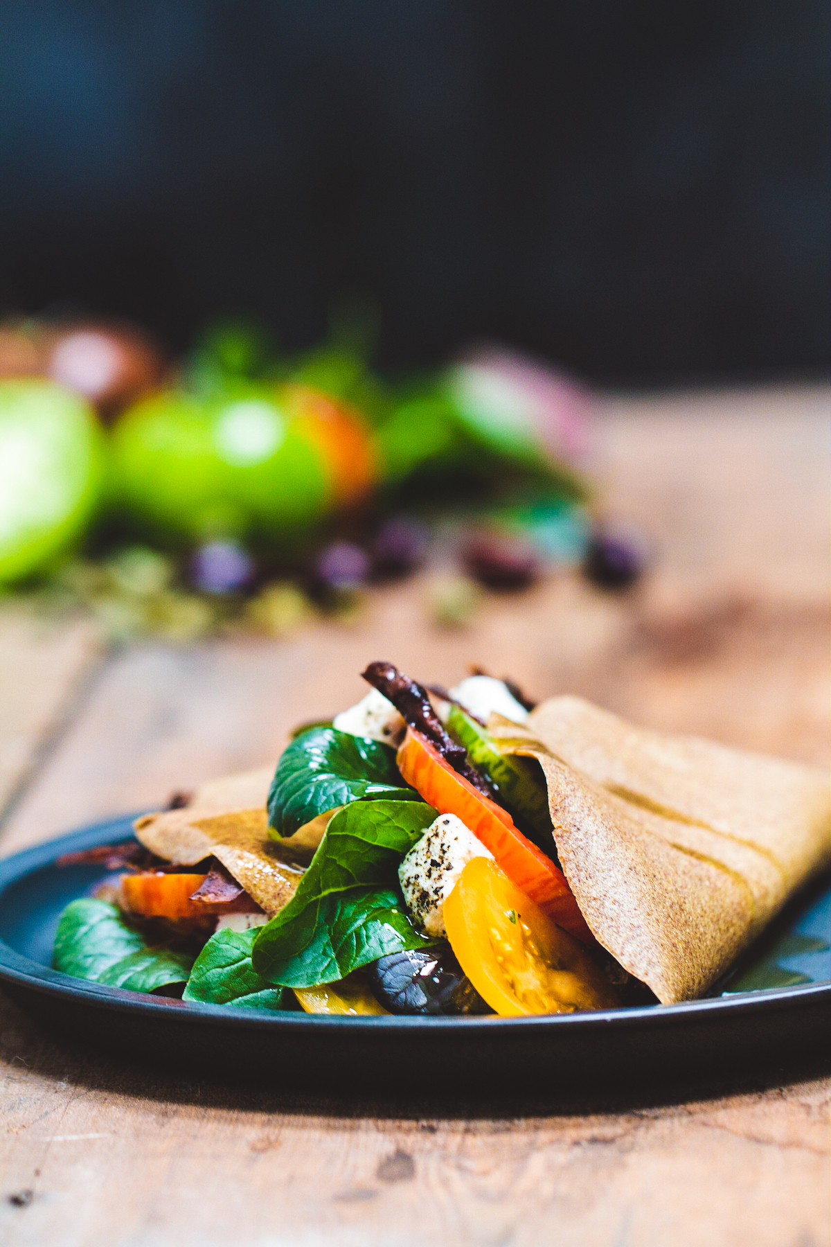 Raw Greek breakfast wraps on a black plate on a wooden background