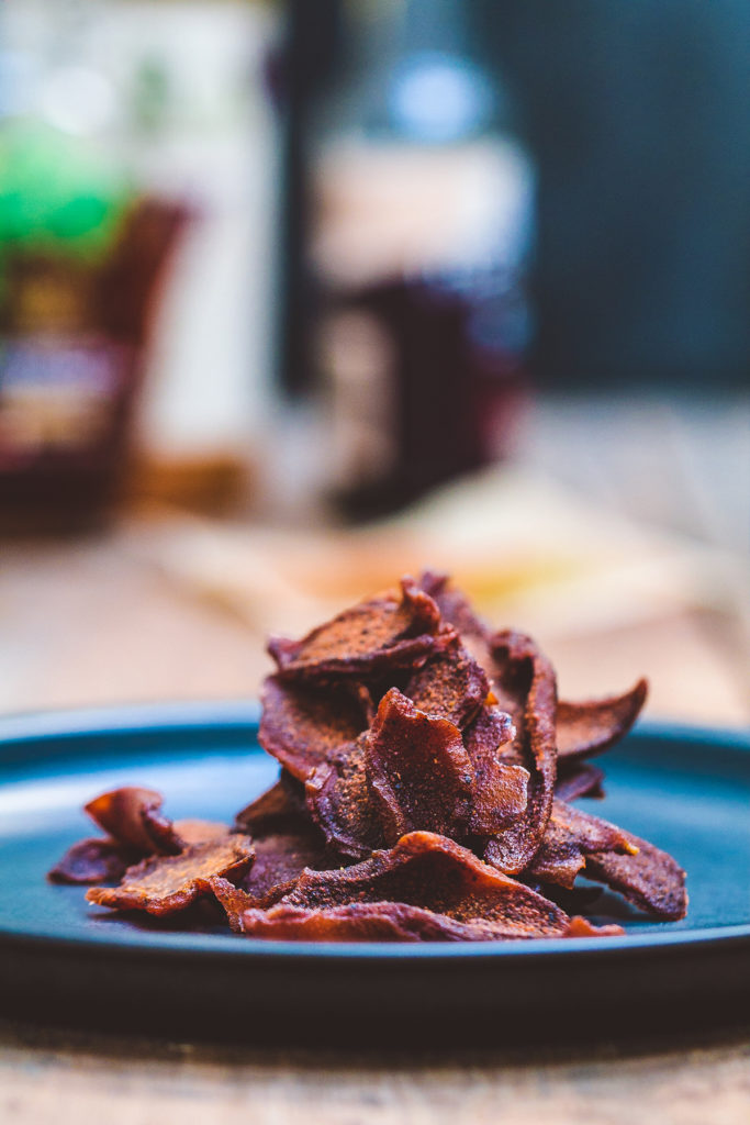 The coconut jerky are stacked on a blue plate