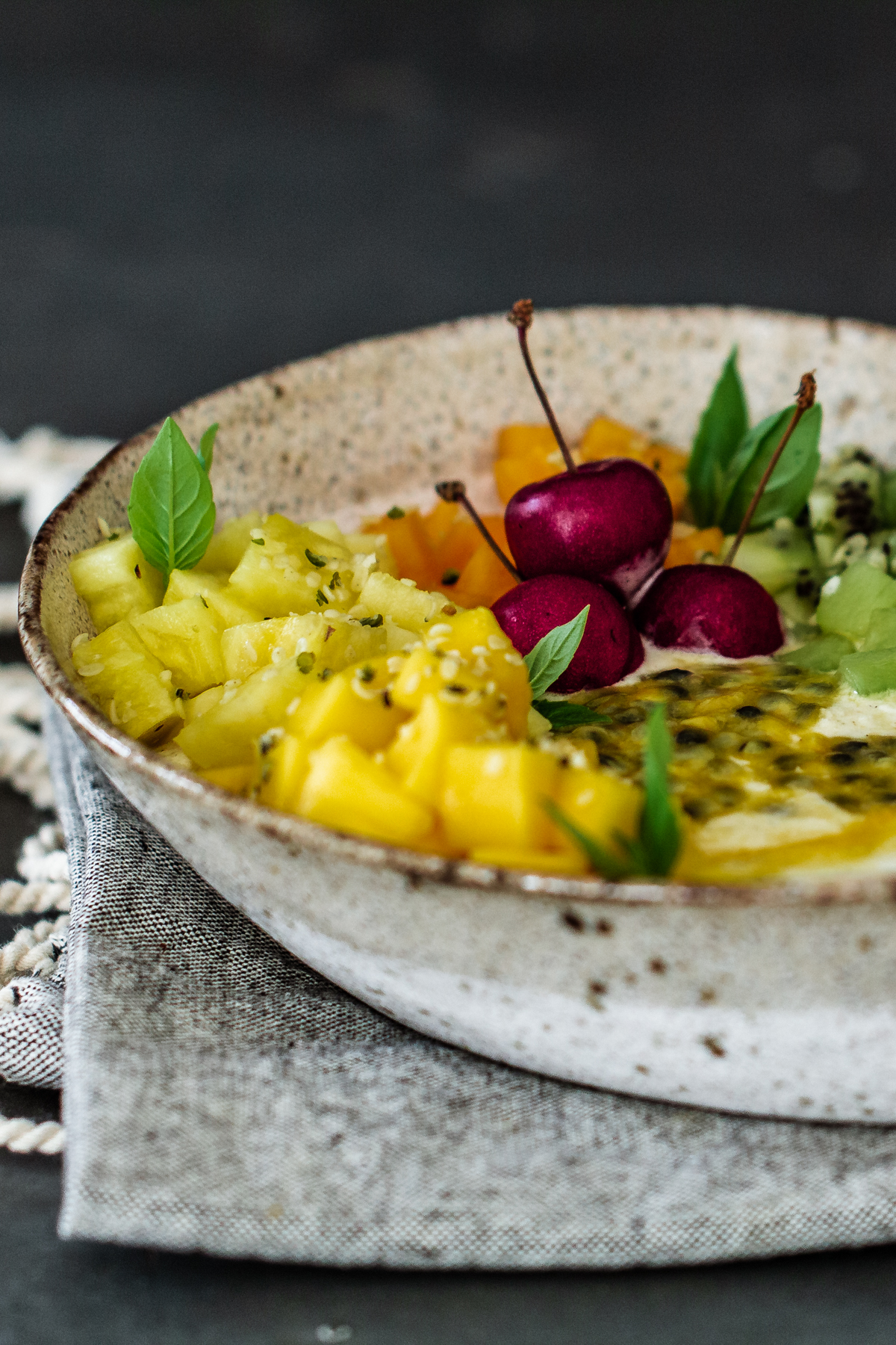 Ambrosia fruit salad breakfast bowl on a napkin and grey background