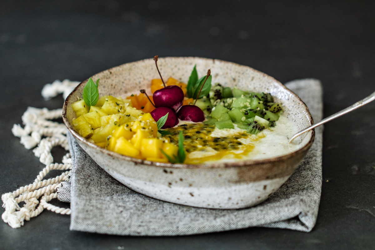 Ambrosia fruit salad breakfast bowl on a napkin and grey background