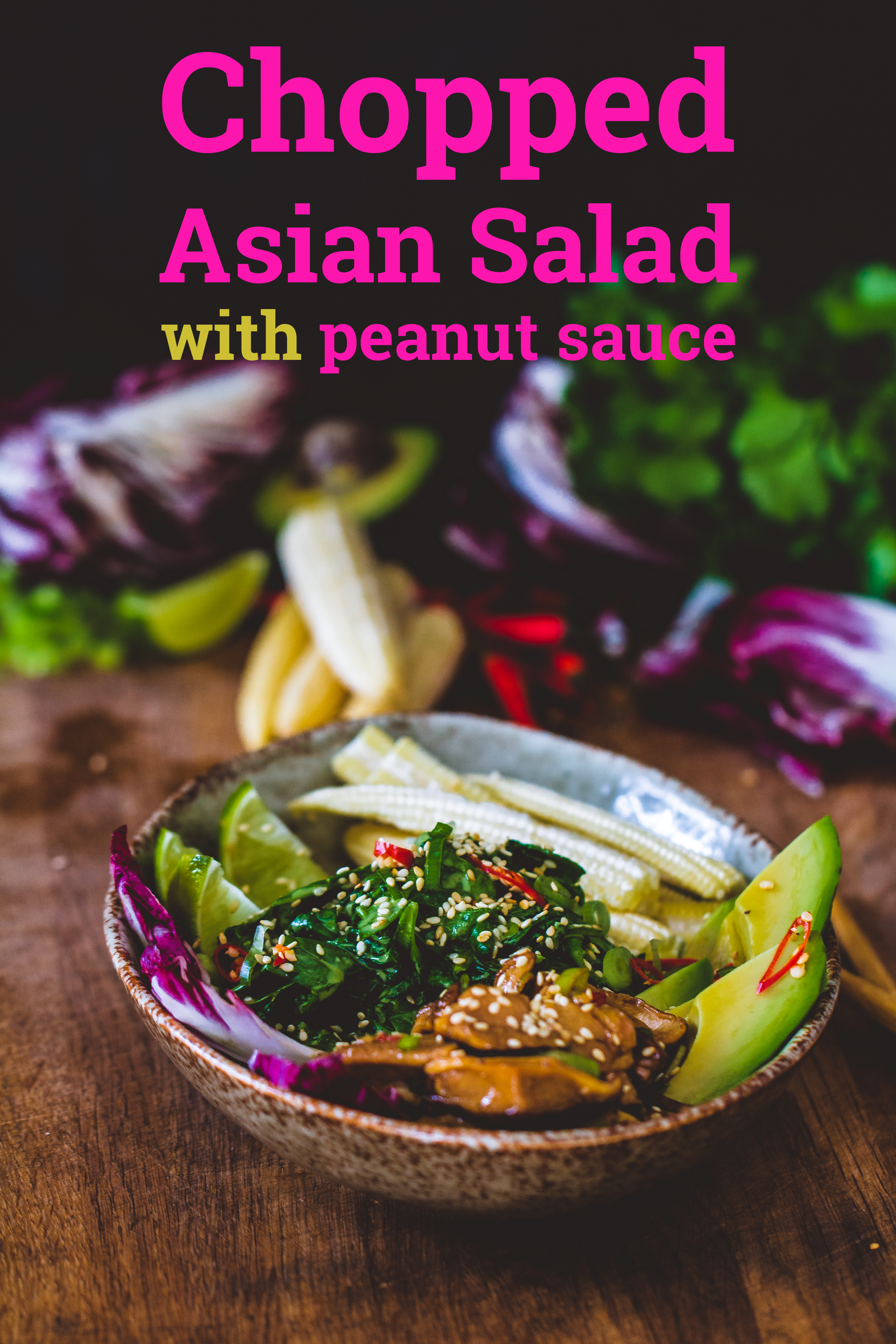 Asian peanut salad dressing on a chopped asian salad in a bowl on a wooden surface with vegetables in the background