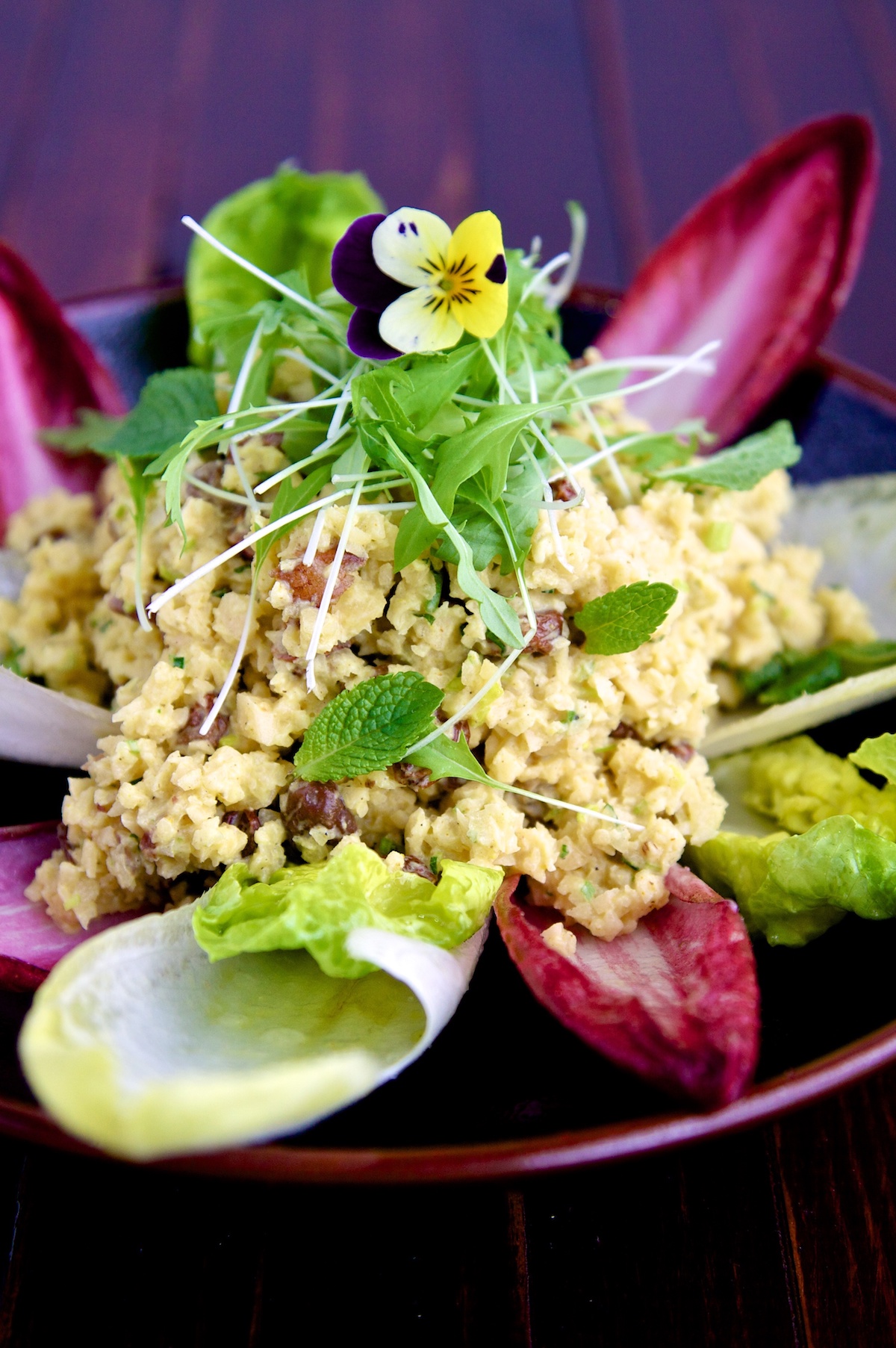 Raw food recipe of curried swede risotto on a brown place and wooden background