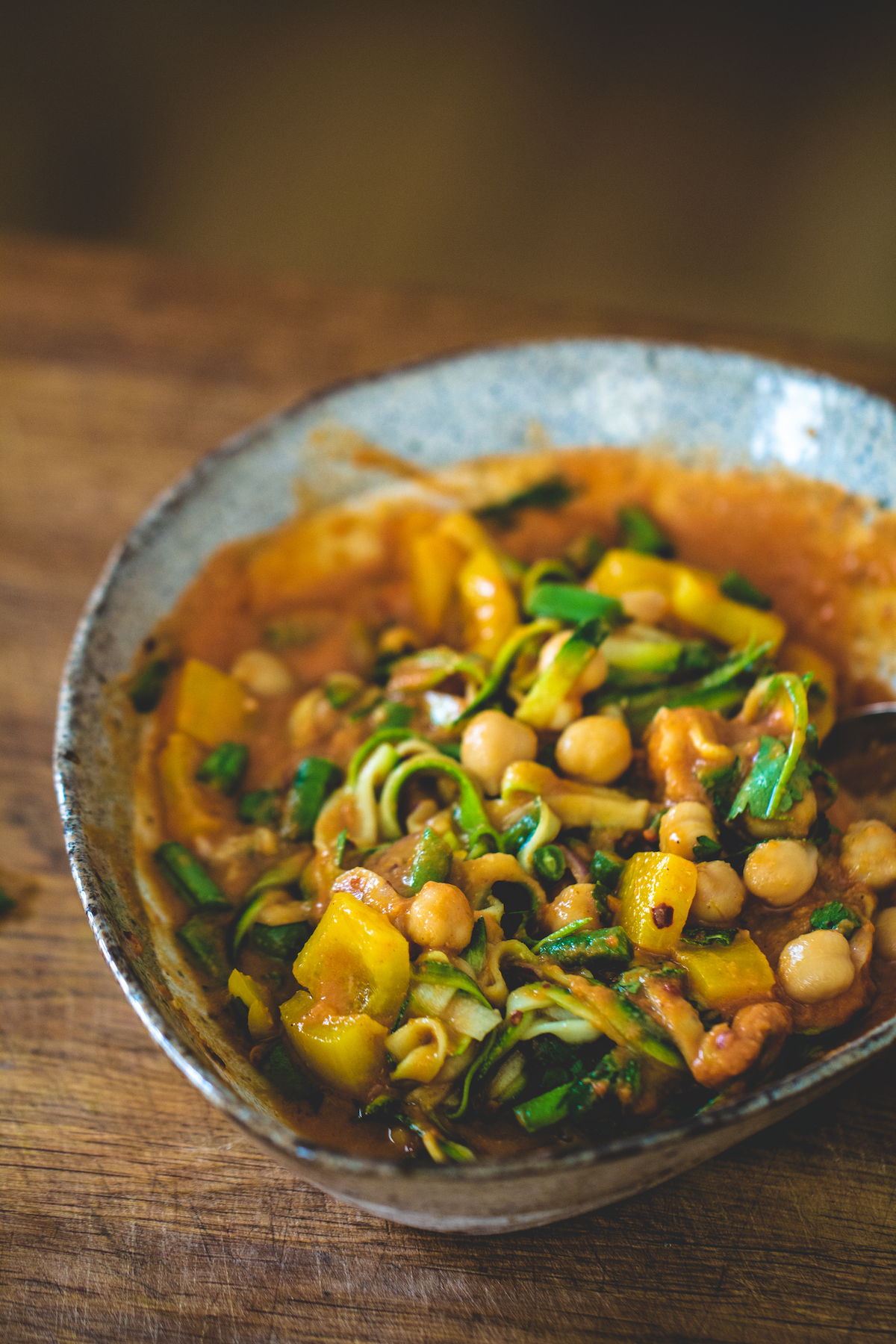 Curried tomato fettuccine in a white bowl on a wooden background