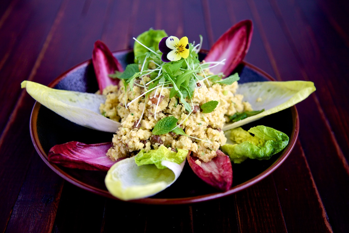 Raw food recipe of curried swede risotto on a brown place and wooden background