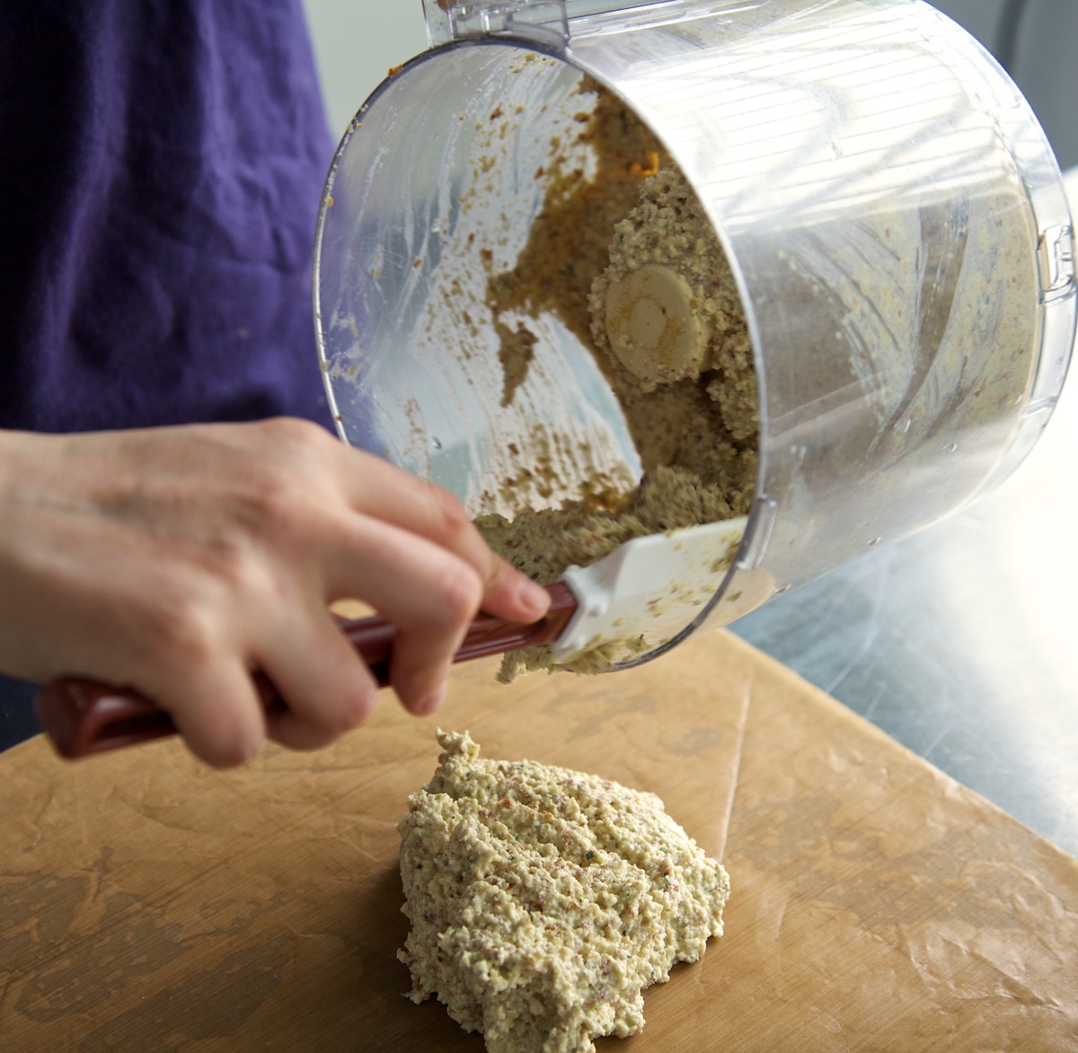 emptying raw crouton mixture from a food processor out on to a nonstick sheet