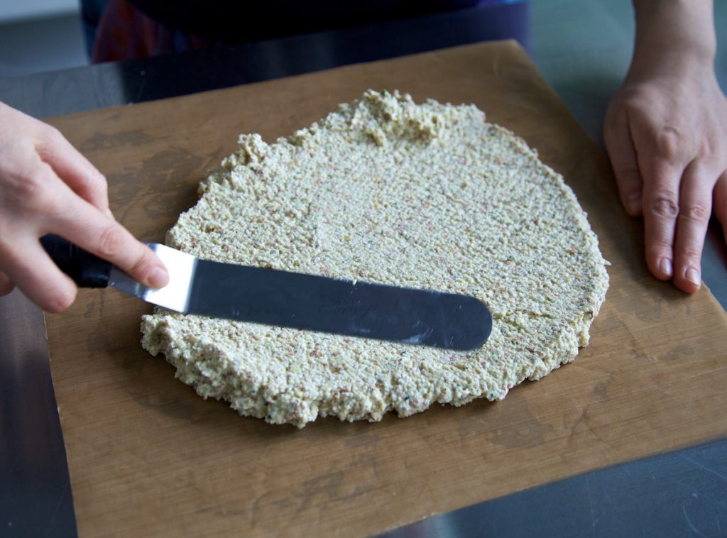 spreading the crouton mix on to a nonstick dehydrator tray