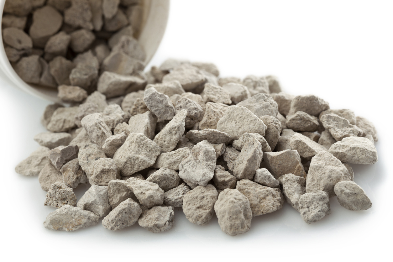 small zeolites stones poured out of a container on a white background