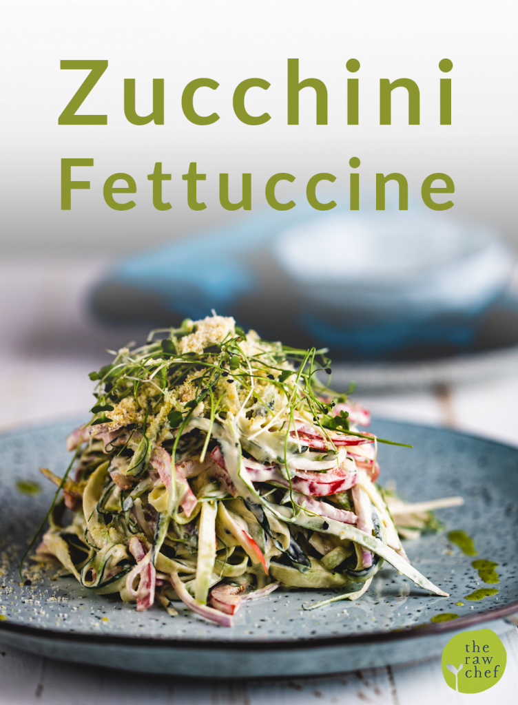 zucchini fettuccine on a blue plate and white wooden surface