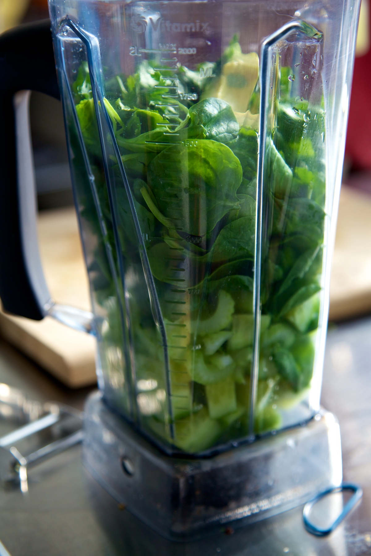 Vitamix jug with raw avocado spinach soup ingredients in.