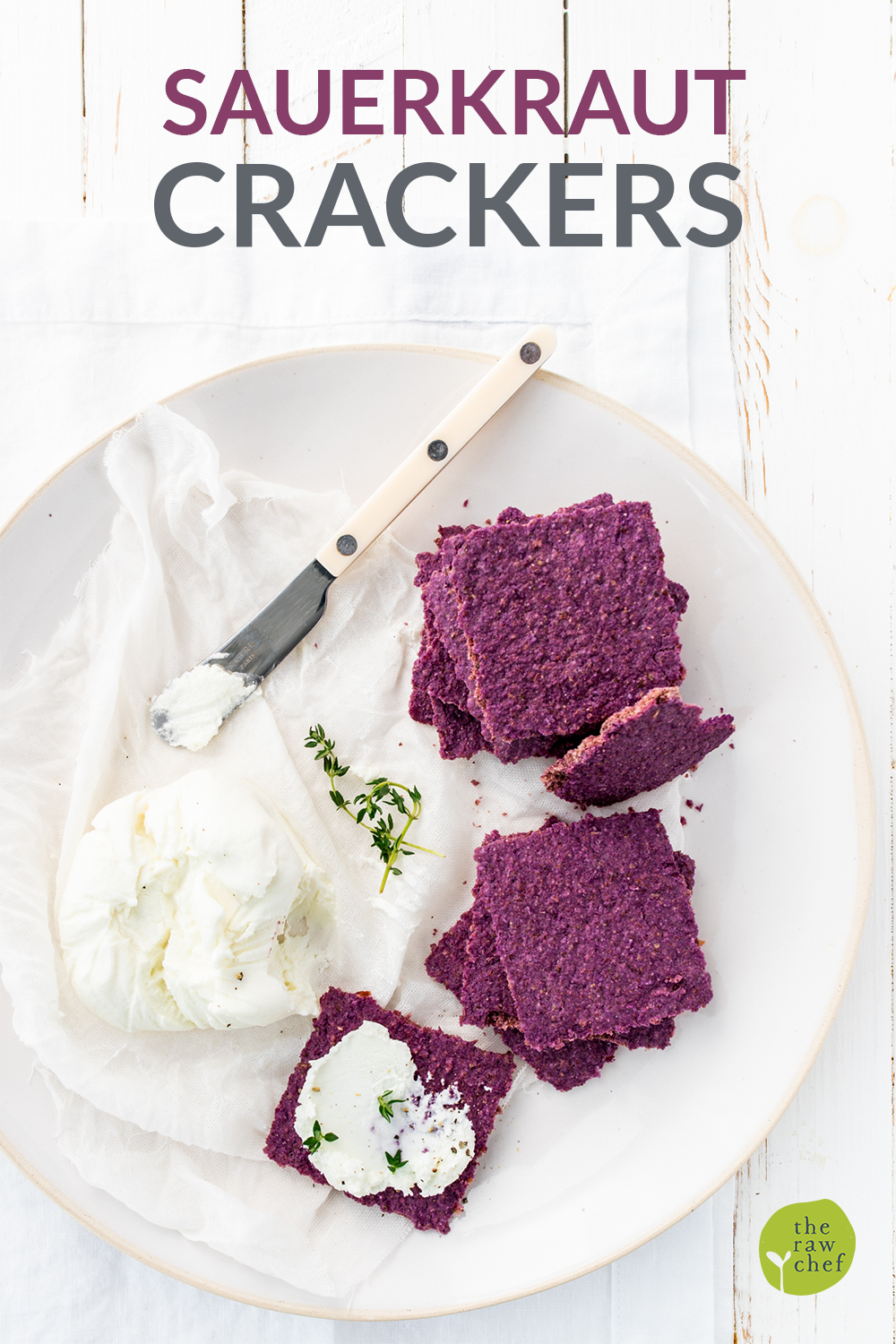 Overhead shot of sauerkraut crackers on a white plate and background, with a butter knife and tree nut cheese.