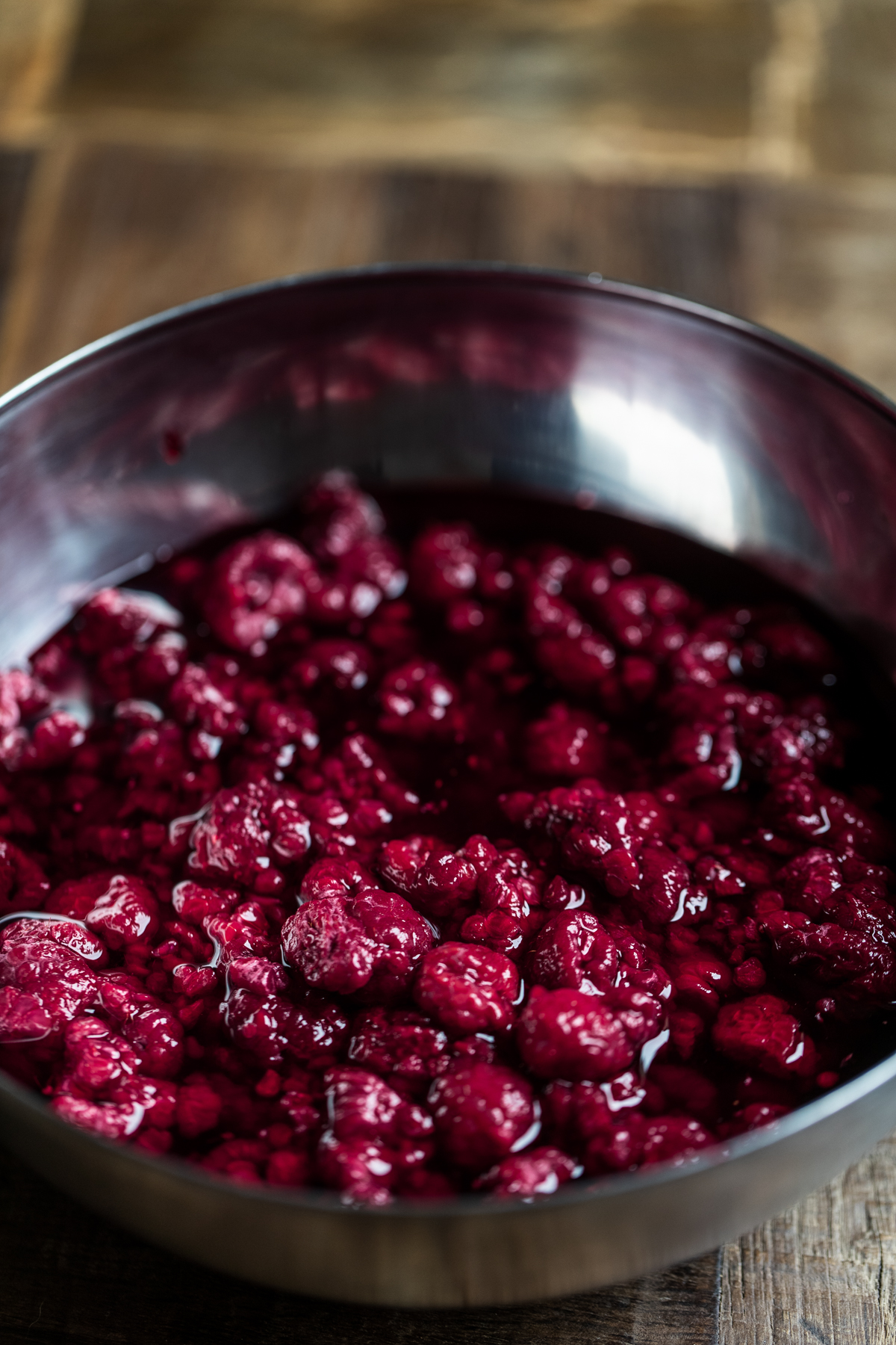 Thawed frozen raspberries in a silver bowl