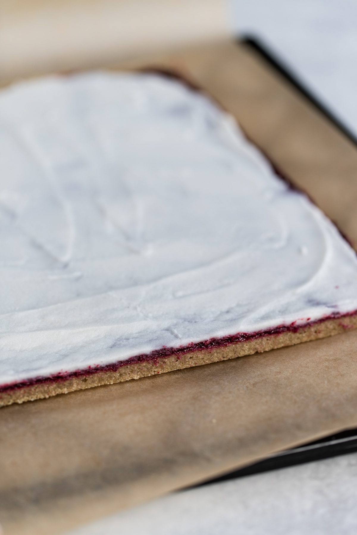 Coconut butter icing spread evenly on swiss roll pastry